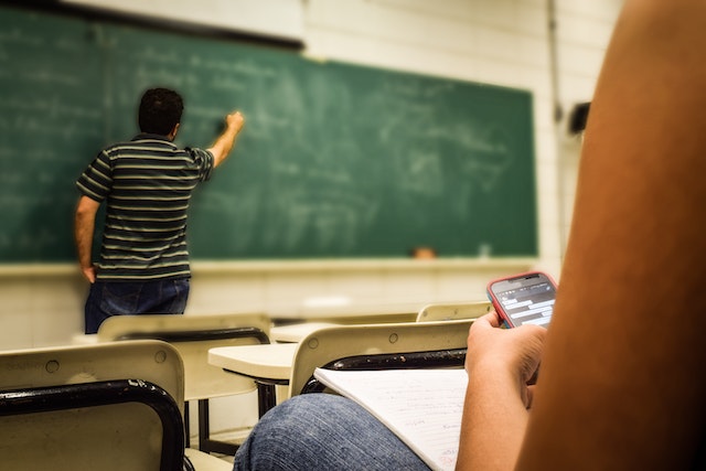 A teacher writing on a blackboard