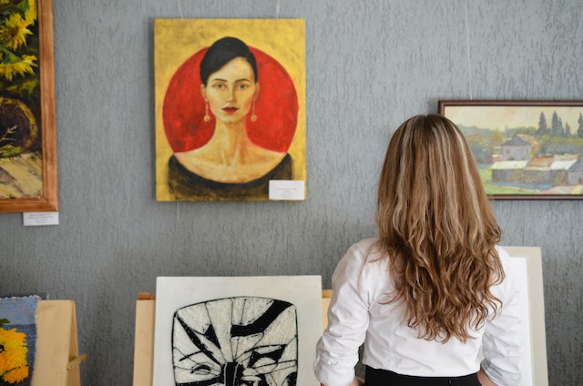 A woman looking at a painting in an art gallery