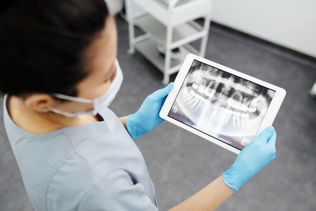 An orthodontist examining an x-ray